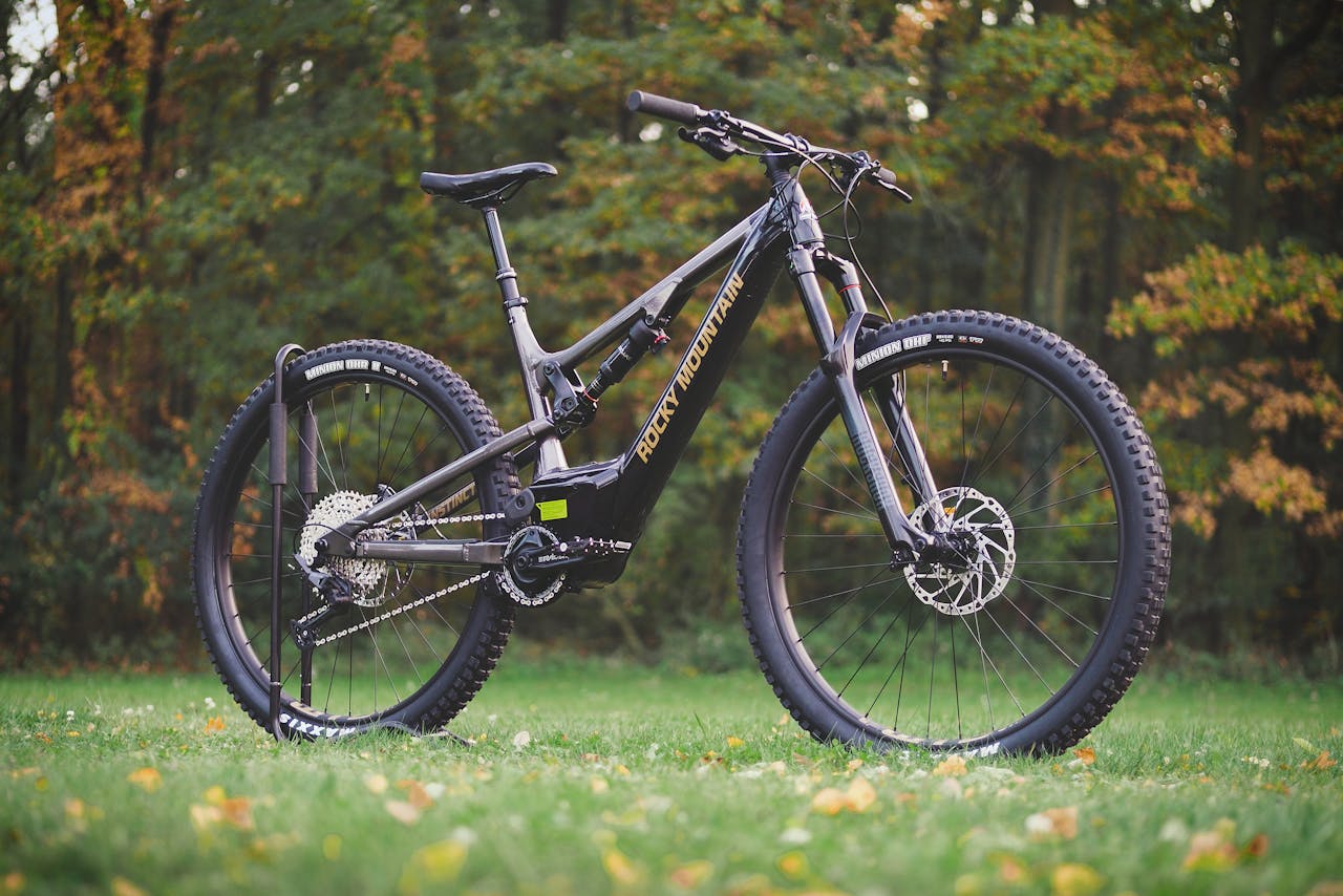 A sleek mountain bike showcased outdoors against a vibrant fall forest backdrop.